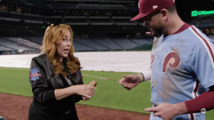 A Woman In A Phillies Jacket Is Shaking Hands With A Baseball Player GIF