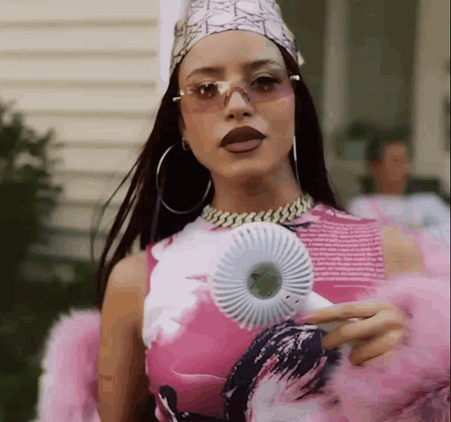 A Woman In A Pink And White Dress Is Holding A Fan GIF