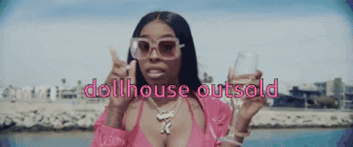 A Woman In A Pink Bikini Is Holding A Glass And The Words Dollhouse Outsold GIF