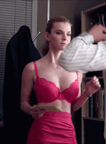 A Woman In A Pink Bra And Skirt Is Holding A Piece Of Paper GIF