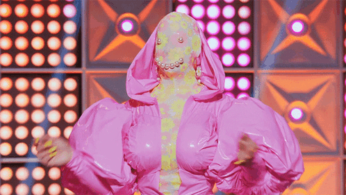 Woman In Pink Costume With Hood And Pearls GIF