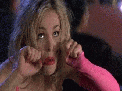 A Woman In A Pink Dress And Pink Gloves Is Making A Face . GIF