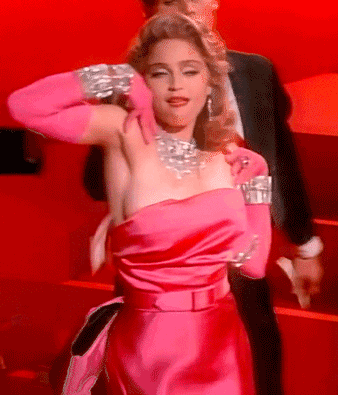 A Woman In A Pink Dress And Pink Gloves Is Standing Next To A Man In A Suit GIF