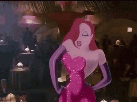 A Woman In A Pink Dress And Purple Gloves Is Standing In A Crowded Room . GIF