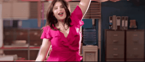 A Woman In A Pink Dress Is Dancing In A Room GIF