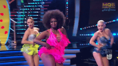 a woman in a pink dress is dancing on stage