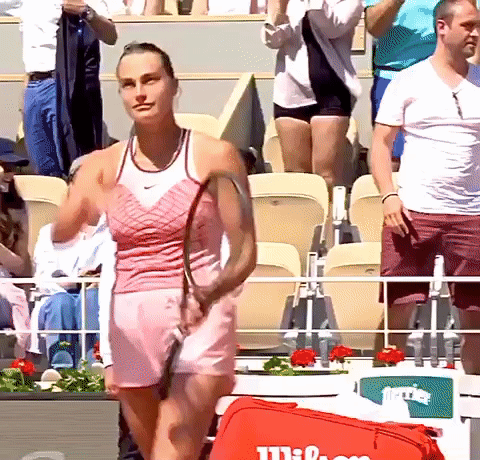 a woman in a pink dress is holding a tennis racquet
