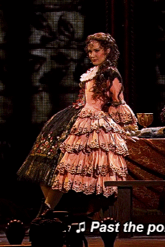 A Woman In A Pink Dress Is Singing Past The Po GIF