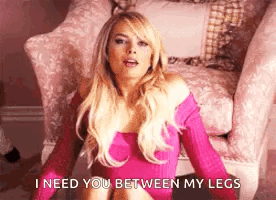 A Woman In A Pink Dress Is Sitting In A Chair . GIF