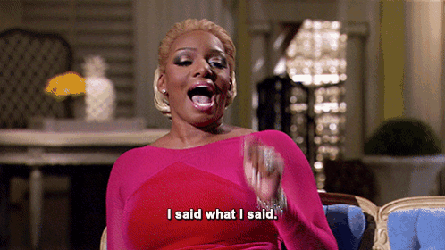 A Woman In A Pink Dress Is Sitting In A Chair And Says I Said What I Said GIF