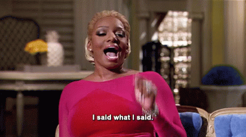 A Woman In A Pink Dress Is Sitting In A Chair With Her Mouth Open And Saying `` I Said What I Said '' . GIF