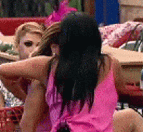 A Woman In A Pink Dress Is Sitting Next To Another Woman . GIF