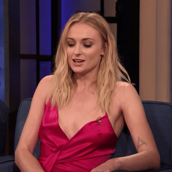 A Woman In A Pink Dress Is Sitting On A Blue Couch GIF
