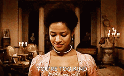 A Woman In A Pink Dress Is Standing In A Room And Smiling . GIF