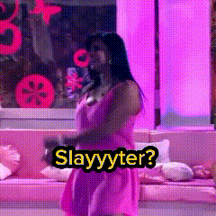 A Woman In A Pink Dress Is Standing In Front Of A Couch With The Words Slayyyter On It GIF