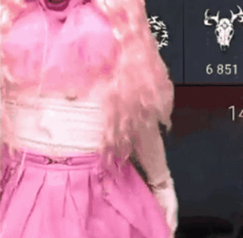 A Woman In A Pink Dress Is Standing In Front Of A Wall With A Deer Skull On It . GIF