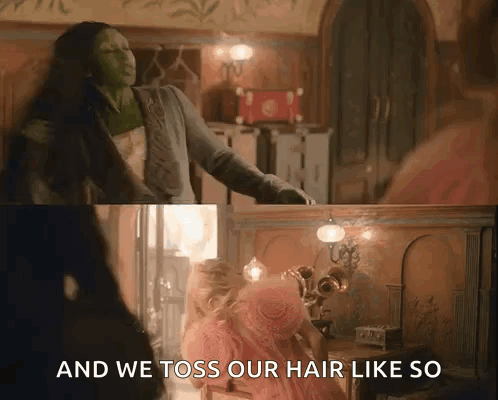 A Woman In A Pink Dress Is Standing Next To A Woman In A Green Dress In A Room . GIF