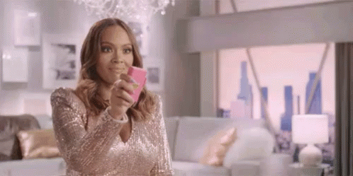 A Woman In A Pink Dress Is Taking A Selfie With Her Cell Phone . GIF