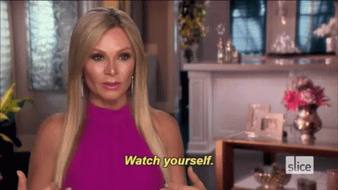 A Woman In A Pink Dress Is Talking To Someone And Says Watch Yourself . GIF