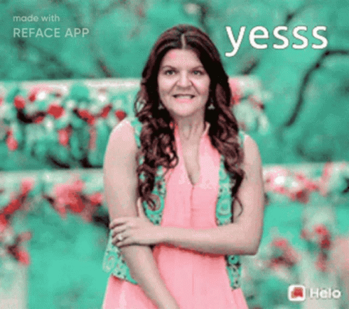 a woman in a pink dress stands in front of a green background with the word yesss written above her