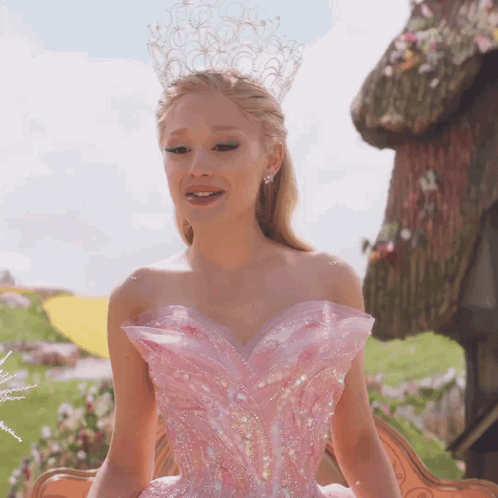 A Woman In A Pink Dress With A Crown On Her Head Is Smiling GIF