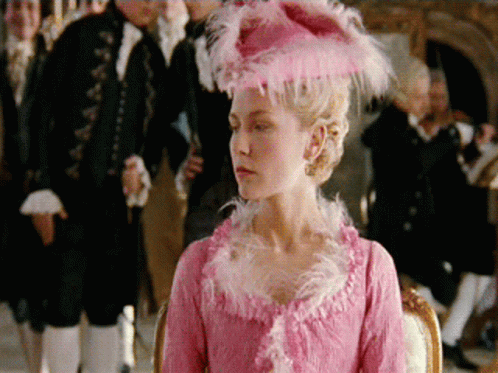 A Woman In A Pink Dress With A Pink Hat GIF
