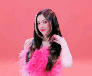 A Woman In A Pink Dress With Feathers On It GIF