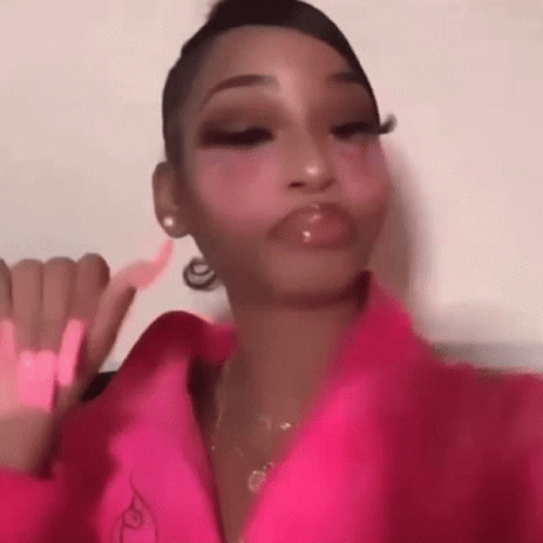 A Woman In A Pink Jacket Is Making A Face . GIF