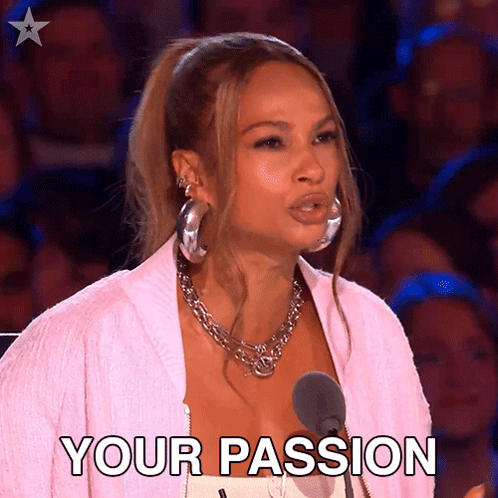 A Woman In A Pink Jacket Stands In Front Of A Microphone And Says " Your Passion " . GIF