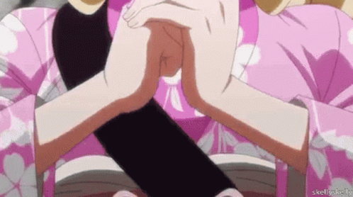 A Woman In A Pink Kimono Is Holding A Black Object Between Her Hands . GIF