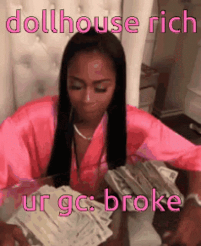A Woman In A Pink Robe Is Sitting At A Table With A Stack Of Money . GIF