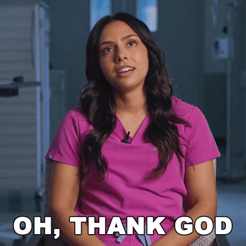 A Woman In A Pink Scrub Is Sitting In A Chair And Says Oh Thank God GIF