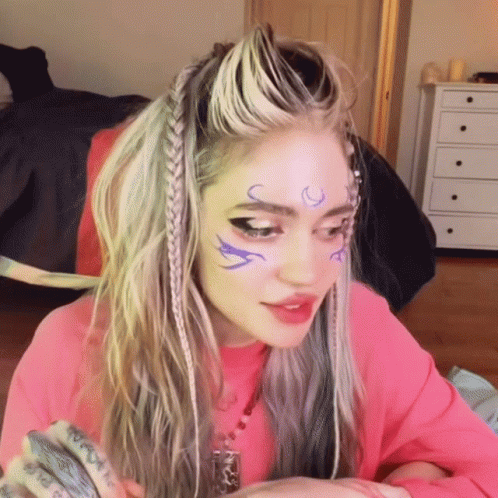 A Woman In A Pink Shirt Has A Tattoo On Her Forehead That Says ' I Love You ' GIF