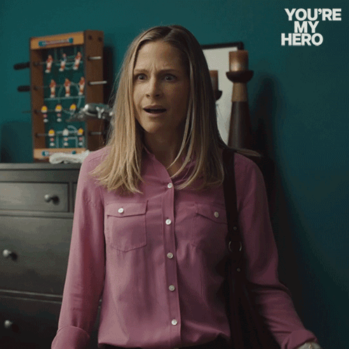 A Woman In A Pink Shirt Is Holding A Cell Phone And Says " Of Course " GIF