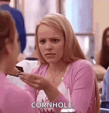 A Woman In A Pink Shirt Is Holding A Piece Of Cake In Her Hand And Talking To Another Woman . GIF
