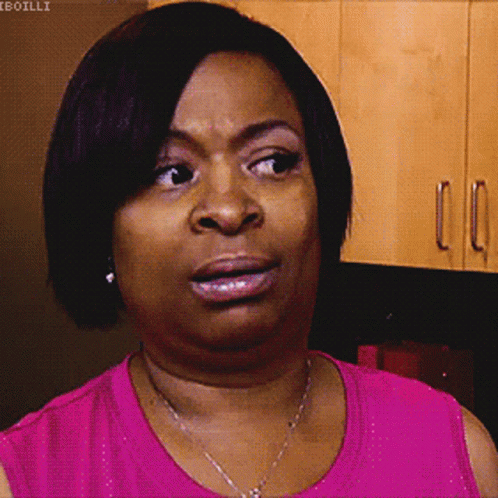 A Woman In A Pink Shirt Is Making A Face GIF