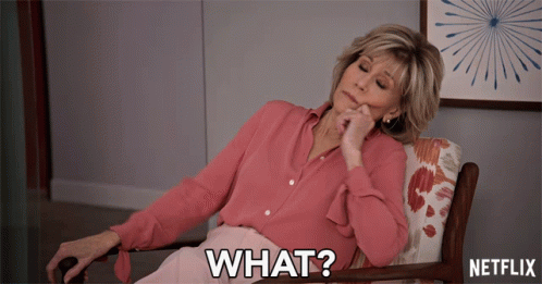 A Woman In A Pink Shirt Is Sitting In A Chair With The Words What On The Bottom GIF