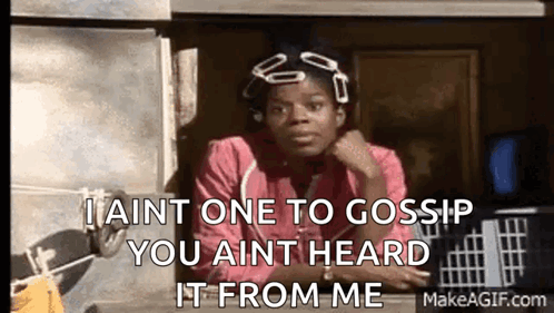 A Woman In A Pink Shirt Is Sitting In Front Of A Window And Talking To Someone . GIF