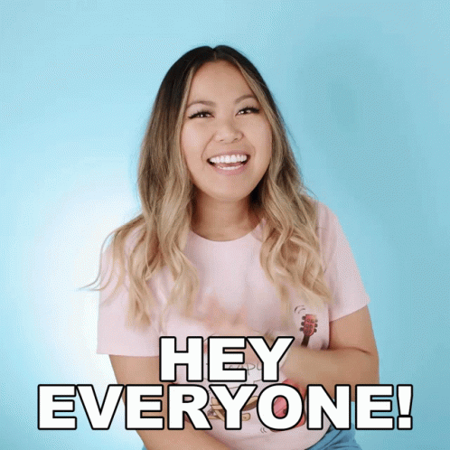 A Woman In A Pink Shirt Is Smiling And Saying Hey Everyone GIF