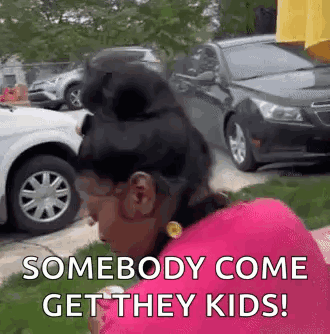 A Woman In A Pink Shirt Is Standing In Front Of A Bunch Of Cars . GIF