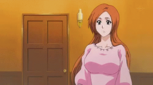 a woman in a pink shirt is standing in front of a door in a room .