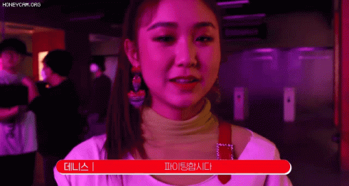 A Woman In A Pink Shirt Is Standing In Front Of A Red Sign That Says ' I 'M Sorry ' . GIF
