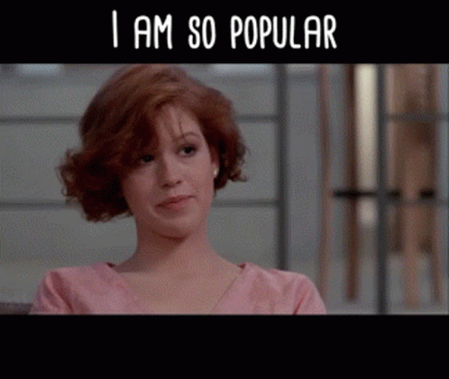 A Woman In A Pink Shirt With The Words " I Am So Popular " Below Her GIF