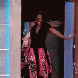 Woman In Pink Skirt Standing In Doorway GIF