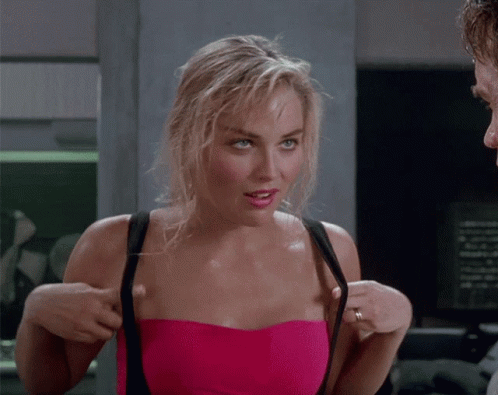 A Woman In A Pink Strapless Top Adjusts Her Straps GIF