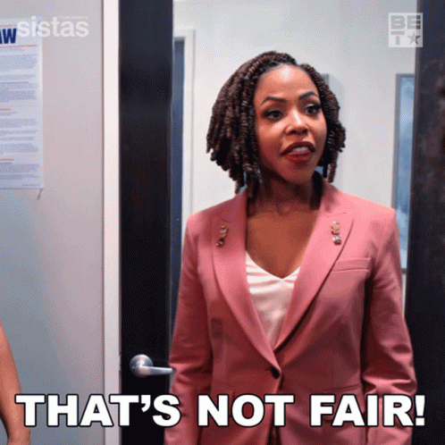 a woman in a pink suit has the words that 's not fair on her chest