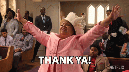 A Woman In A Pink Suit Says Thank Ya In Front Of A Netflix Logo GIF