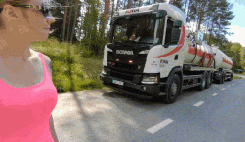 A Woman In A Pink Tank Top Looks At A Scania Truck GIF