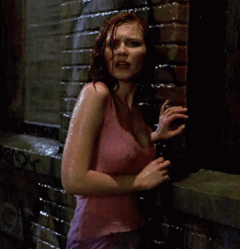 A Woman In A Pink Tank Top Stands In The Rain GIF