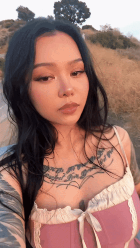 A Woman In A Pink Top Has A Tattoo On Her Chest That Says " I 'M A Girl " GIF